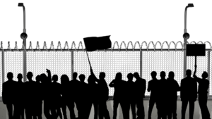 Man sieht die Silhuetten von streikenden Personen vor einem Zaun.
