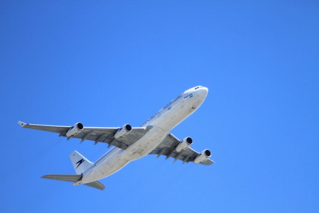 Es ist ein startendes Flugzeug vor wolkenlosen, blauem Himmel zu sehen.
