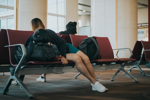 Mann schläft am Flughafen