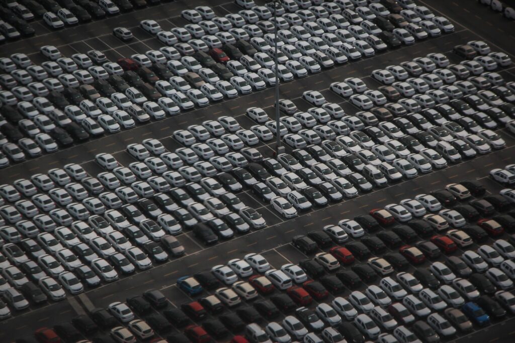 Man sieht einen großen Parkplatz mit Autos aus der Vogelperspektive.