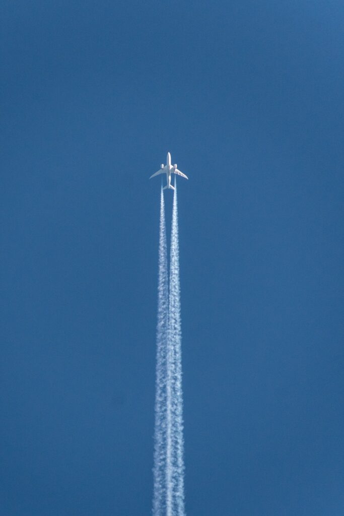 Flugzeug von unten vor blauem Himmel