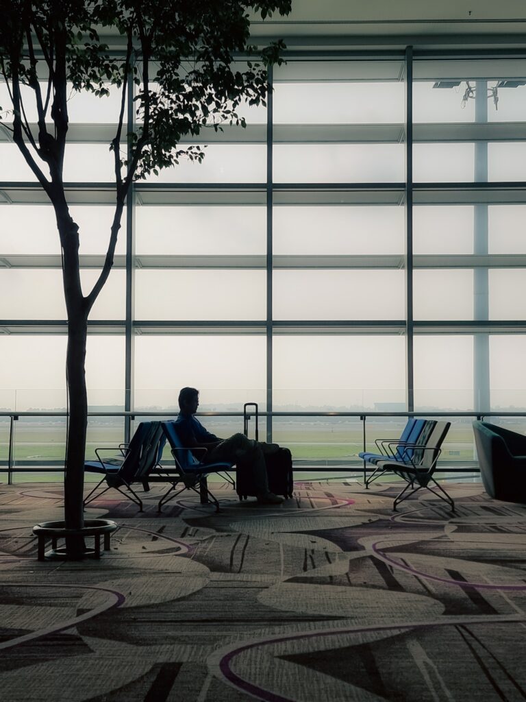 Mann sitzt im Terminal am Flughafen