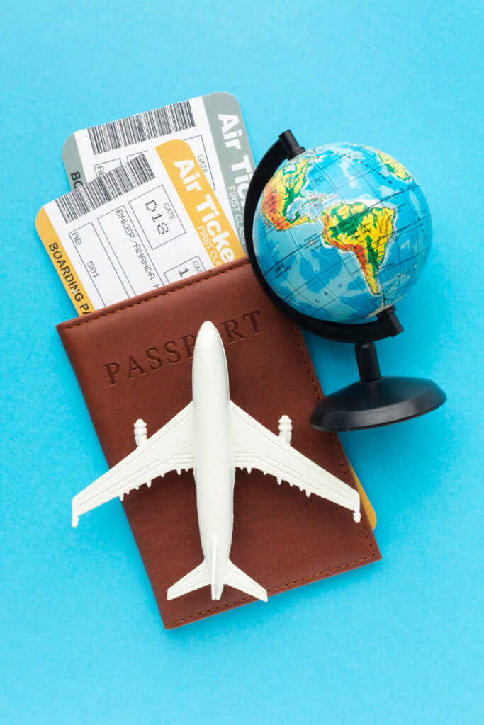 Flugtickets mit Pass, Modellflugzeug und Globus