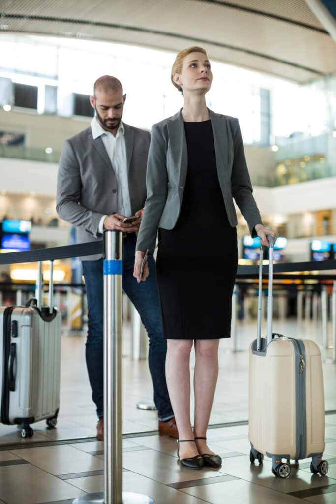 Geschaeftsreisende beim Check In Flughafen 