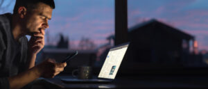 Mann bucht Flug am Laptop und wundert sich über Dynamic Pricing.