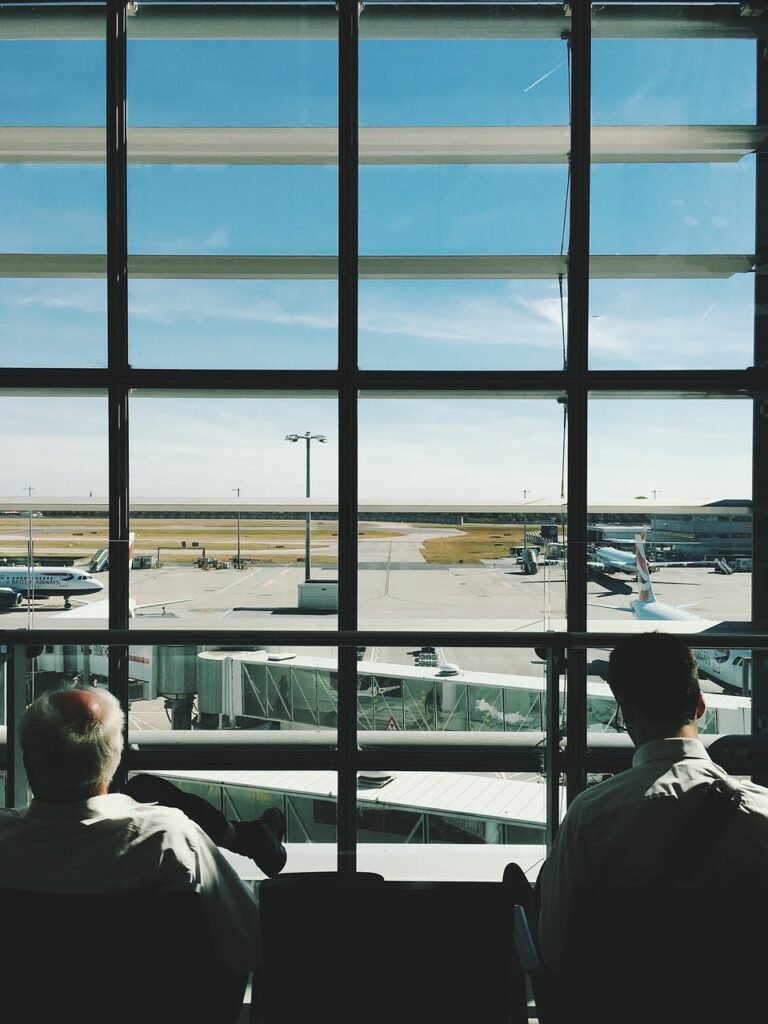 Wartende Menschen am Flughafen Gate schauen aus dem Fenster.