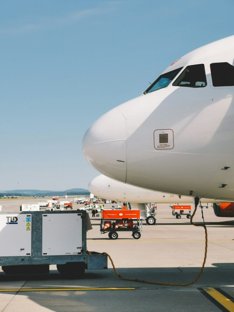 Weißes Flugzeug vor blauem Himmel wird betankt.