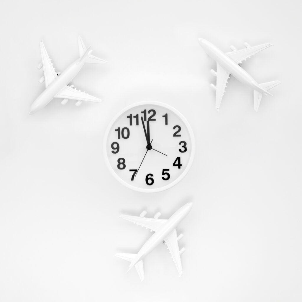 Uhr mit Ziffernblatt in der Mitte, darum drei Modellflugzeuge im Kreis.